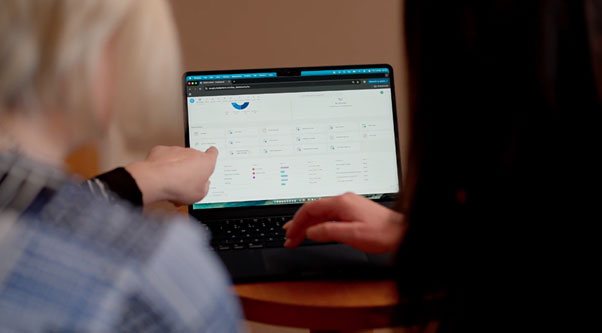 Two business professionals collaborating on laptop in modern office