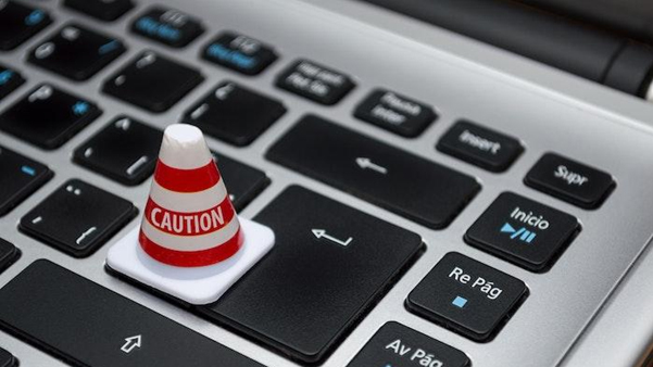 Red alert button on black keyboard representing urgent action required