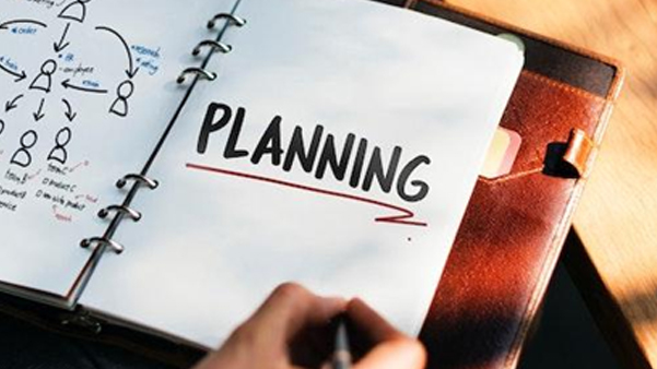 Open spiral notebook with planning written representing business strategy