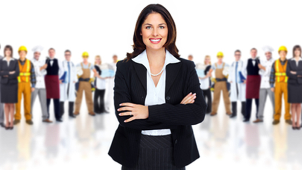 Confident professional businesswoman standing with diverse team members