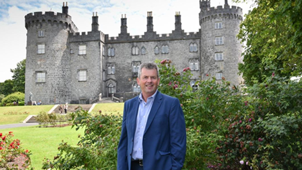 Professional businessman standing at historic Irish castle grounds