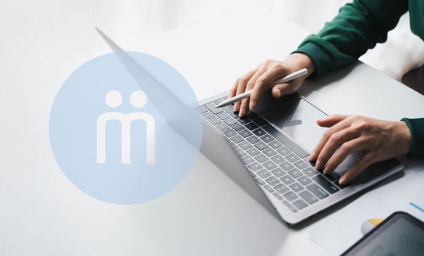 Professional using MindaClient CRM software on laptop at desk