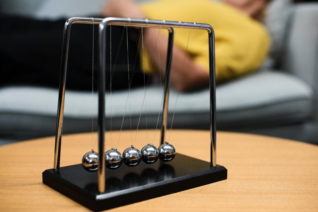 Newton cradle balance balls representing business cause and effect