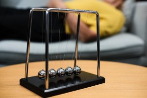 Newton cradle balance balls representing business cause and effect