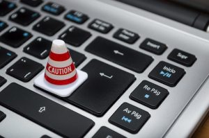 Red alert button on black computer keyboard close-up