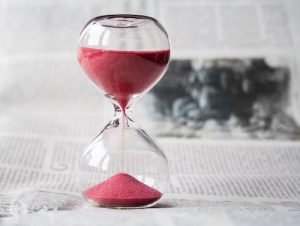 Red hourglass on desk representing time management in business