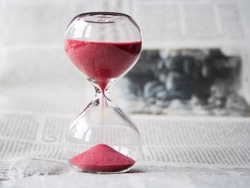 Red hourglass on desk representing time management in business