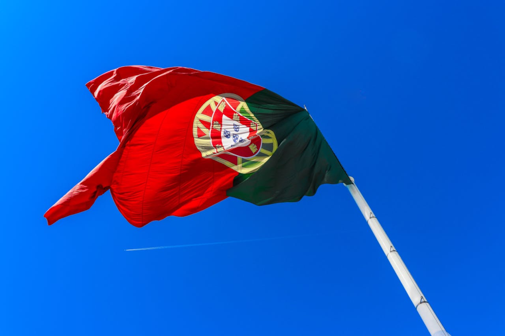 Portugal national flag waving against blue sky