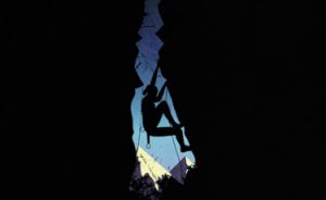 Silhouette of rock climber scaling a mountain wall