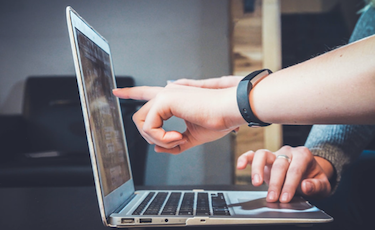 Business professional pointing at laptop screen
